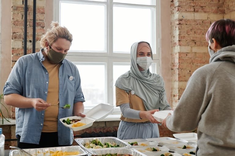 Muslim volunteers serving food at a community event illustrating the power of volunteering in Islam